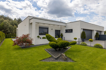 Outside view of elegant suburban house with big window green lawn