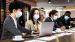 © Bangkok Click Studio - Multiracial mixed race businesspeople group working with concentration  at office, wearing face masks as new normal to protect or prevent virus in pandemic crisis, using laptop and job discussion.