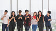 © Bangkok Click Studio - Group of seven young male and female teenagers standing and playing their smartphones and tablet. Junior friends using a mobile phone without talking. Concept of social media addicted in adolescent