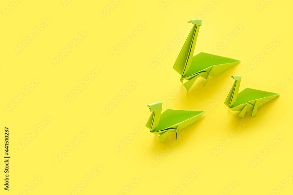 Origami dinosaurs on color background. Concept of uniqueness