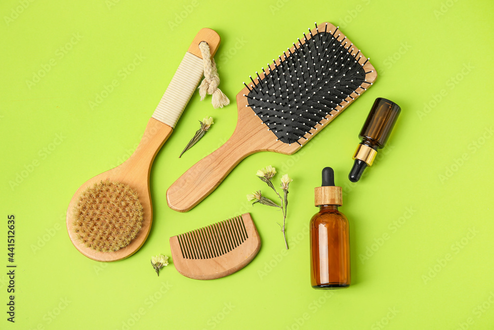Composition with hair brush, comb and cosmetics on color background