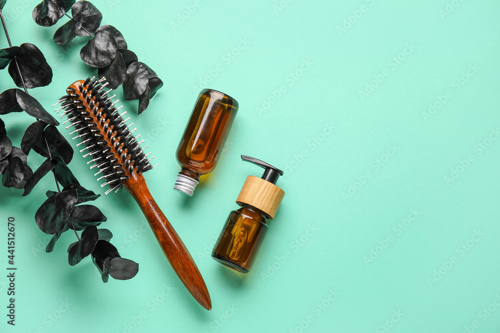 Hair brush and cosmetics on color background