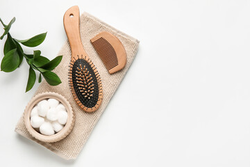 Hair brush, comb, towel and cotton balls on white background