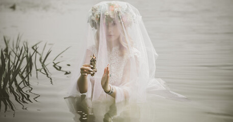 Bride making magic of candles, magical attributes, herbs and flowers, Slavic/ Wicca rituals and esoteric concept