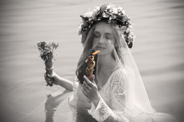 Bride making magic of candles, magical attributes, herbs and flowers, Slavic/ Wicca rituals and esoteric concept