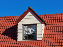 Pitched Roof Dormer Loft With White Window And Red Concrete Tiles
