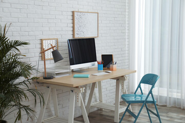 Sticker - Stylish home office interior with comfortable workplace near white brick wall