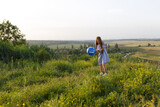 Fototapeta Kuchnia - happy girl with red hair and blue dress having fun with an balloon in nature