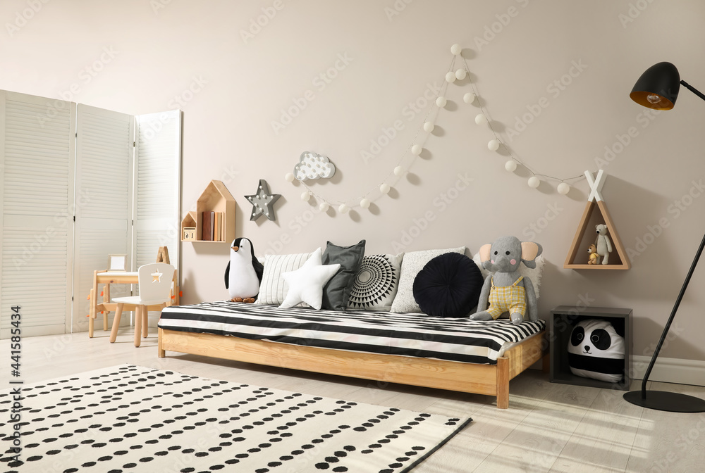 Cute kids room with stylish comfortable floor bed and toys. Montessori interior - obrazy, fototapety, plakaty 