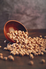 Uncooked dried chickpeas in wooden bowl