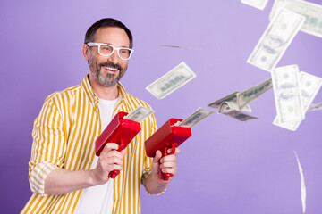 Sticker - Photo of confident lucky mature man dressed striped shirt spectacles smiling shooting money gun isolated violet color background