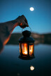 © ADDICTIVE STOCK - Hand with chandelier near water at night