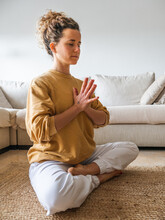 Woman Sitting On The Floor In Lotus Pose During Meditation
