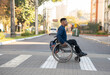 profile of black man with wheelchair crossing the street.