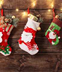 Wall Mural - Christmas stocking with gifts hanging on dark old wooden background