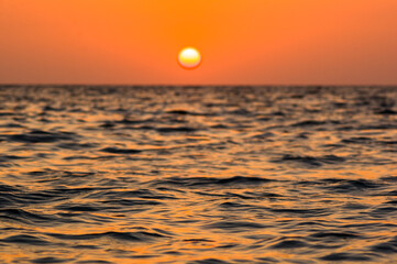Wall Mural - Amazing sea sunset on the pebble beach, the sun, waves, clouds