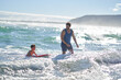 © Trevor Adeline/Caia Image - Father and son body boarding in sunny summer ocean surf