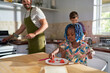 © Trevor Adeline/Caia Image - Family cooking and eating in kitchen