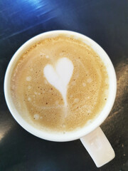 Poster - Vertical top view of a delicious hot cappuccino with a milk heart on top