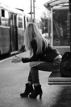 Grayscale Shot Of A Cool Blonde Woman Sitting On A Subway Bench