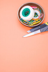 Sticker - Top view of colorful paper clips, adhesive tape, a stationery knife, and scissors