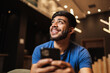 © Nexa - Young latin man using cell phone. Texting on cafe.