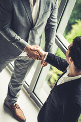 Businessman handshake with another businessman partner in modern workplace office. People corporate business deals concept.