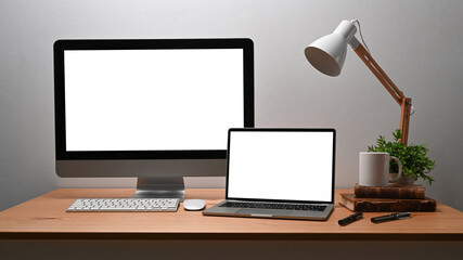 Front view computer pc and laptop on wooden table.