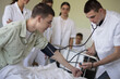 © liderina - Young student male in hospital measures the patient's pressure.
