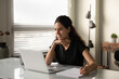 © fizkes - Smiling Caucasian woman sit at desk in office work online on laptop consult client or customer. Happy successful businesswoman busy with computer job at workplace, consider brainstorm with documents.