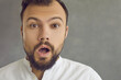 © Studio Romantic - Closeup studio portrait of surprised bearded young man gazing open mouthed at camera. Close up shot of handsome guy looking at you with shocked face expression