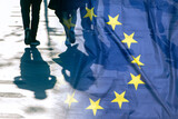 Fototapeta  - EU or European Union Flag and shadows of people, concept political picture.