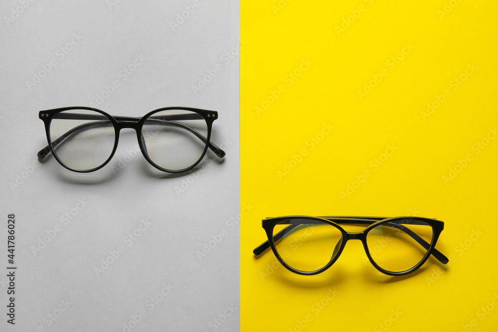 Different stylish eyeglasses on color background