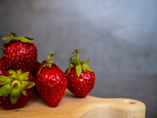 Fresh, ripe strawberries lie on a wooden board, and on a concrete, gray table. Berry. Background and texture.