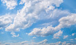 Panoramic picture with Fluffy White Clouds on a blue sky.
