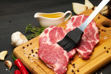 Fresh raw beef or pork steaks on wooden cutting board