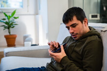 Serious Blind Man Using Smartphone On Sofa