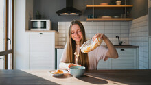 Smiling Woman Pouring Corn Rings Into Bowl In Kitchen