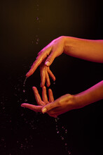 Hands Of Woman Doing Gestures In Color Lights And Water