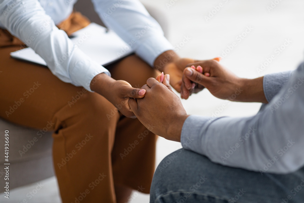 Professional compassion. Psychotherapist supporting her depressed male patient, holding his hand indoors, closeup - obrazy, fototapety, plakaty 