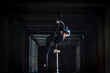 Female flexible circus artist doing handstand in abandoned tunnel. Concept of individuality, creativity and outstanding