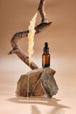 Fototapeta  - bottle with micellar water, essence of natural oil, serum serum for the face. Brown glass bottle with pipette on sandstone stone and a beautiful branch of pine
