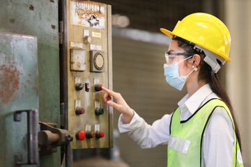 Wall Mural - Portrait of woman Asian mechanic engineer worker wearing safety equipment beside the switch of electric machine system in manufacturing factory