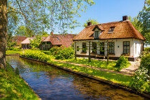 The Famous Village Of Giethoorn In The Netherlands With Traditional Dutch Houses, Gardens And Water Canals And Wooden Bridges Is Know As "Venice Of The North"