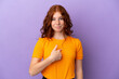 © luismolinero - Teenager redhead girl over isolated purple background with surprise facial expression