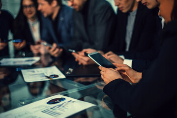 Wall Mural - employees using their smartphones to work with financial data.