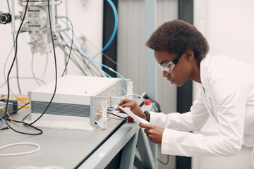 scientist african american woman working in laboratory with electronic tech single photon detector. 