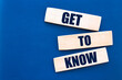 Get to know words on wooden blocks on blue background.