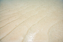 Background Texture Of White Beach Sand And Sea Water