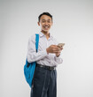 a boy wearing a junior high school uniform smiles while holding a cellphone from an isolated background